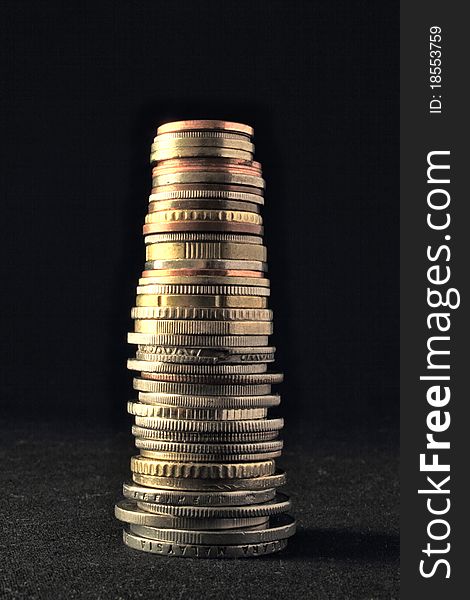 Different international coins with different size and shape make a column. Different international coins with different size and shape make a column