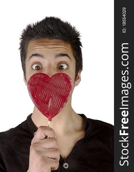 Pakistani teenage boy is looking surprised at a lolly heart. Pakistani teenage boy is looking surprised at a lolly heart