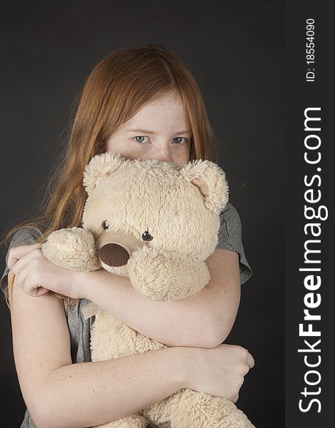 Young girl is cuddling with a teddybear