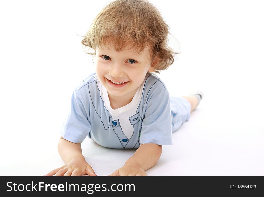 Little boy smiling lying on its belly, white background. Little boy smiling lying on its belly, white background