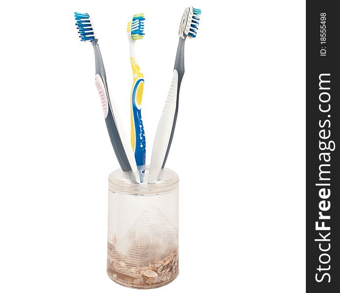 Toothbrushes in a glass on a white background