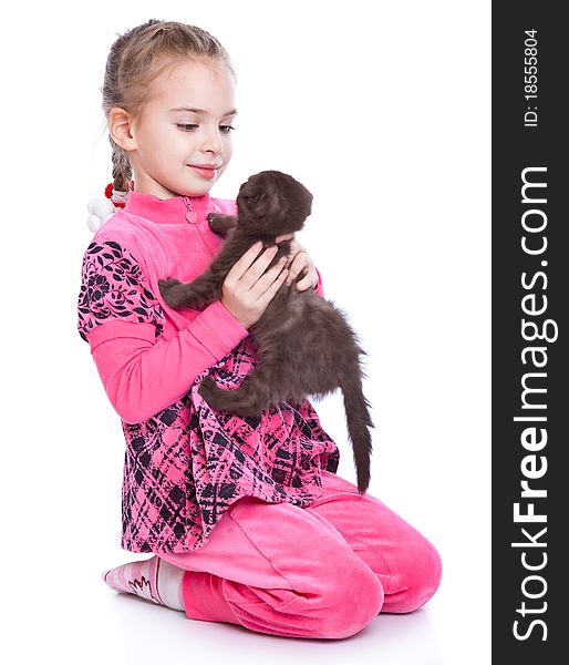 A smiling girl is playing with a kitten. isolated on a white background