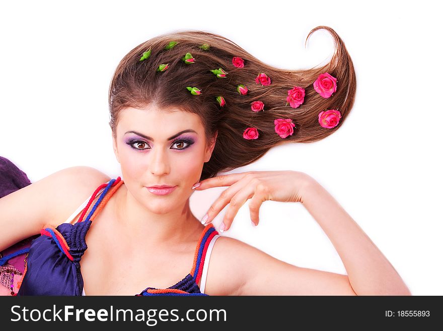 Pretty girl lying with flowers-roses in her hair