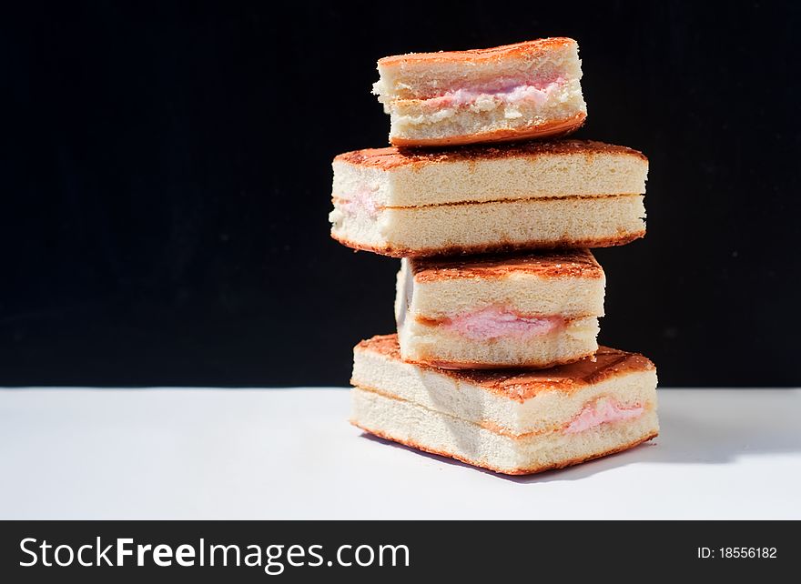 Four orange biscuit cakes on black - white background.