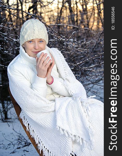 Woman in white with a cup. winter forest. sunset. Woman in white with a cup. winter forest. sunset.