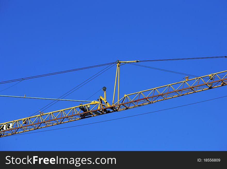 Crane holding a prefabricated element against a limpid sky. Crane holding a prefabricated element against a limpid sky