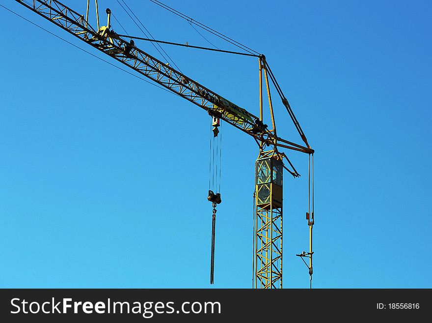 Crane holding a prefabricated element against a limpid sky. Crane holding a prefabricated element against a limpid sky