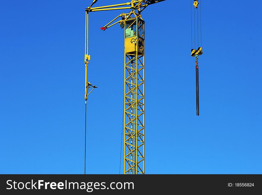 Crane holding a prefabricated element against a limpid sky. Crane holding a prefabricated element against a limpid sky