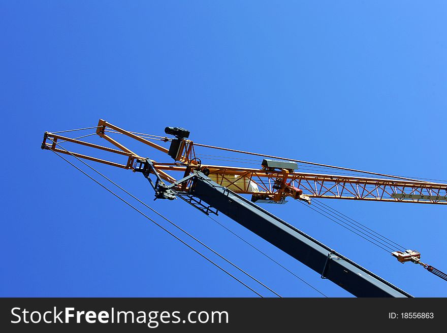 Crane holding a prefabricated element against a limpid sky. Crane holding a prefabricated element against a limpid sky