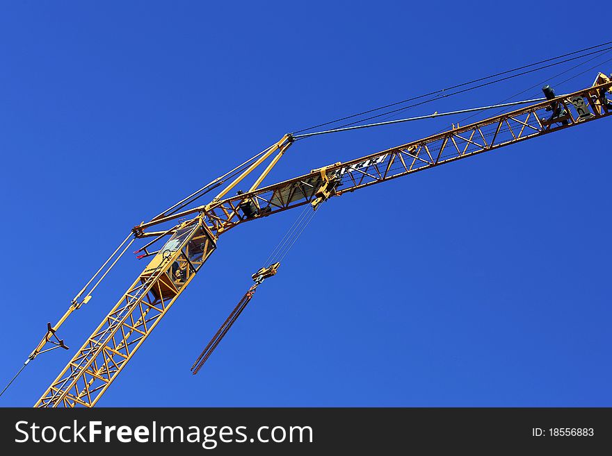 Crane holding a prefabricated element against a limpid sky. Crane holding a prefabricated element against a limpid sky