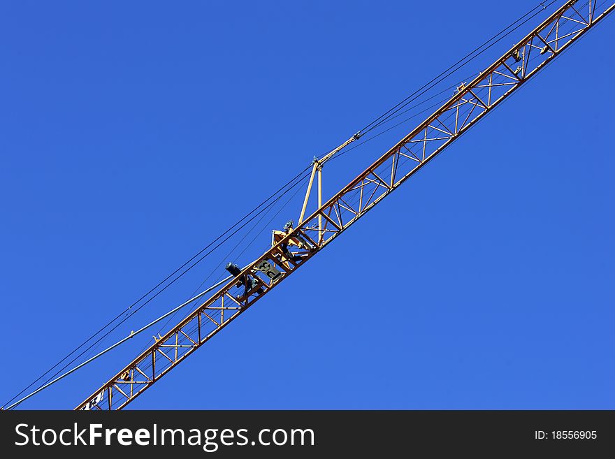 Crane holding a prefabricated element against a limpid sky. Crane holding a prefabricated element against a limpid sky