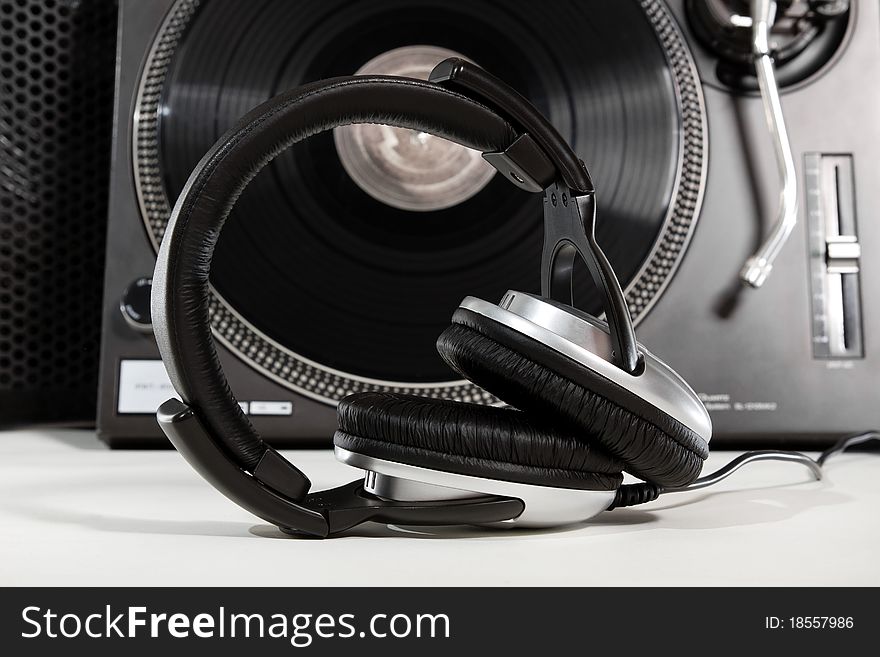 Dynamic studio headphones and turntable record player on white background. Dynamic studio headphones and turntable record player on white background