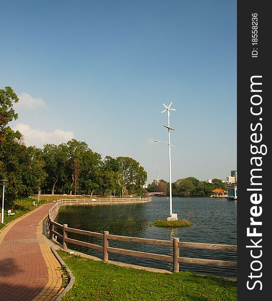 A windmill be encircled with lake in park. A windmill be encircled with lake in park
