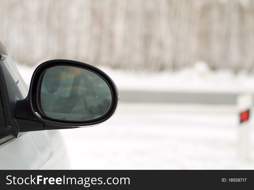 Car mirror on the background of a winter forest