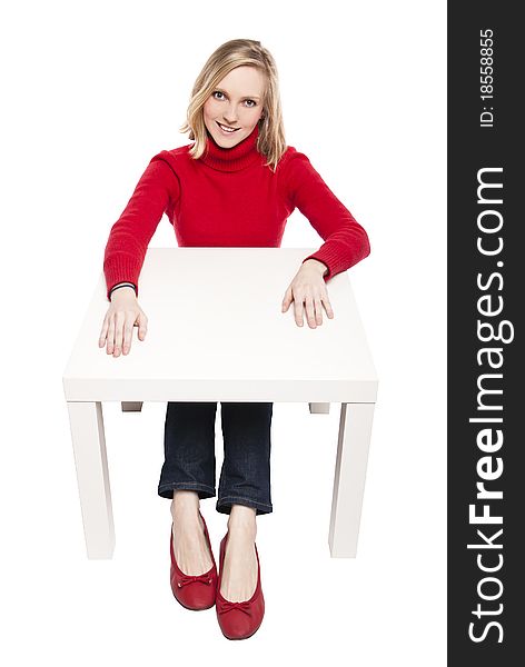 Young woman sitting at funny small desk