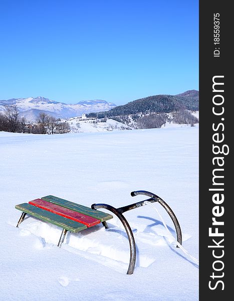 Old sledge with snow and mountine in background. Old sledge with snow and mountine in background