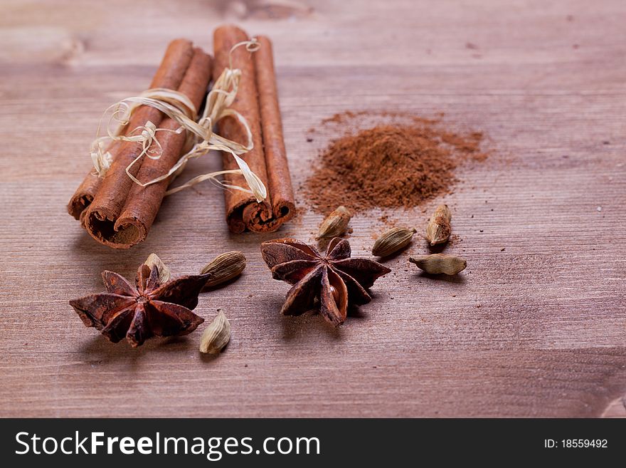 Mix of spice cinnamon, anise, cardamom on wooden table