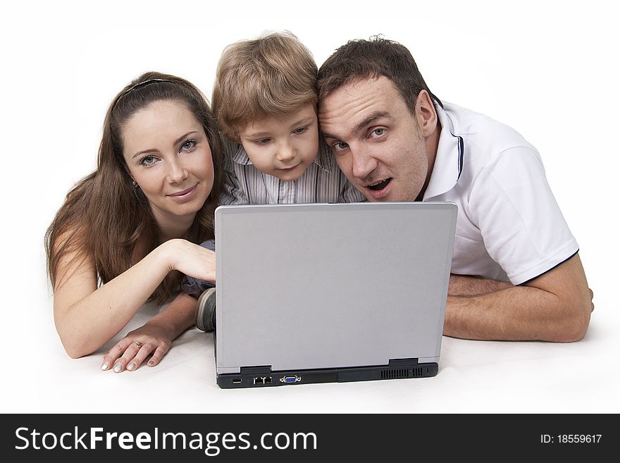 Young family lying on a floor with the computer on white isolation. Young family lying on a floor with the computer on white isolation