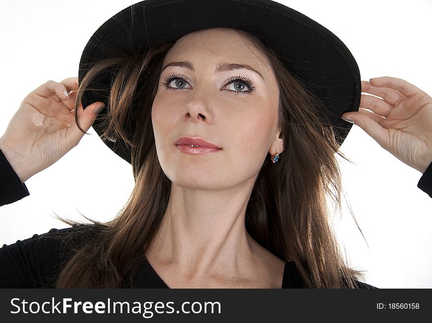 Beautiful young woman and black hat on a white background. Beautiful young woman and black hat on a white background.