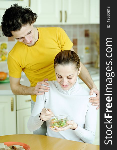 An image of young couple eating at kitchen. An image of young couple eating at kitchen