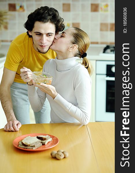 An image of young happy couple eating at kitchen. An image of young happy couple eating at kitchen
