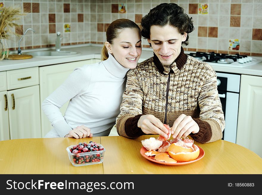 An image of young happy couple eating at kitchen. An image of young happy couple eating at kitchen