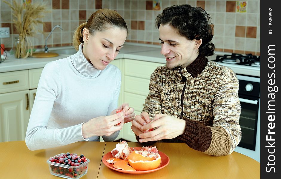 An image of young couple eating at kitchen. An image of young couple eating at kitchen