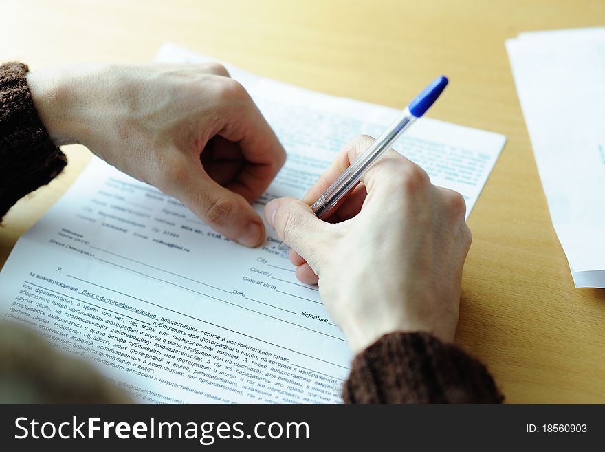 An image of maleï¿½s hand writing in the document. An image of maleï¿½s hand writing in the document