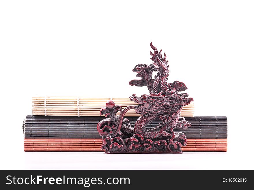 Japanese Dragon Sculpture In Front Of Bamboo Mats