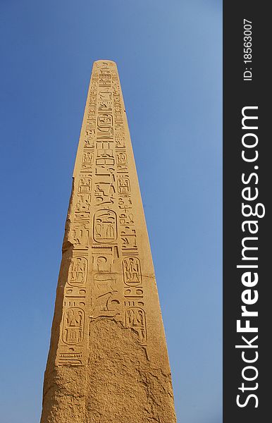 Obelisk on blue sky in a temple of Egypt