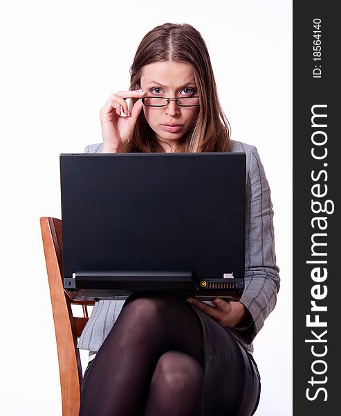 Portrait of young angry woman with notebook is looking over the glasses. Portrait of young angry woman with notebook is looking over the glasses