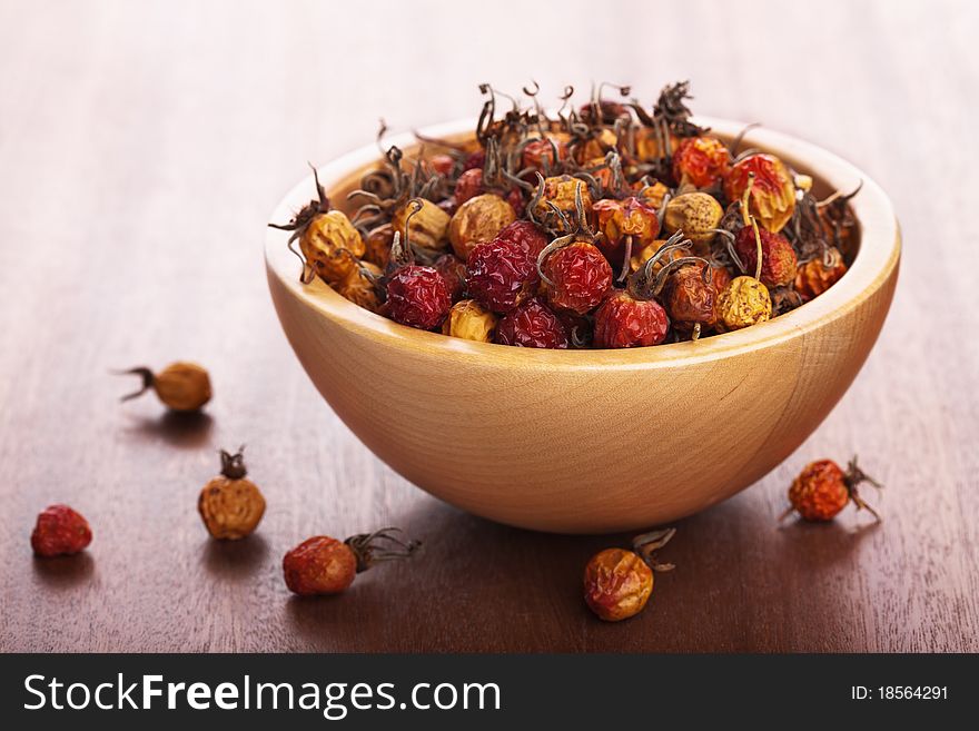 Dried rosehips in wooden bowl