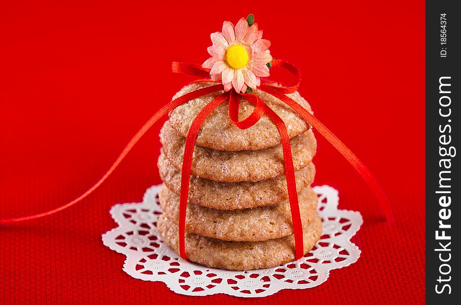 Ginger cookies tied with red ribbon on red background