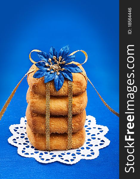 Stack of shorthbread cookies tied with golden ribbon on blue background. Stack of shorthbread cookies tied with golden ribbon on blue background