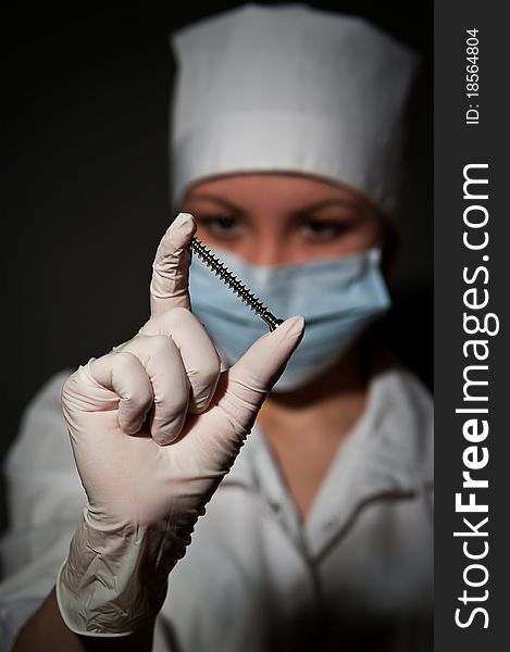 Young pretty surgeon holding nail for osteosynthesis close up