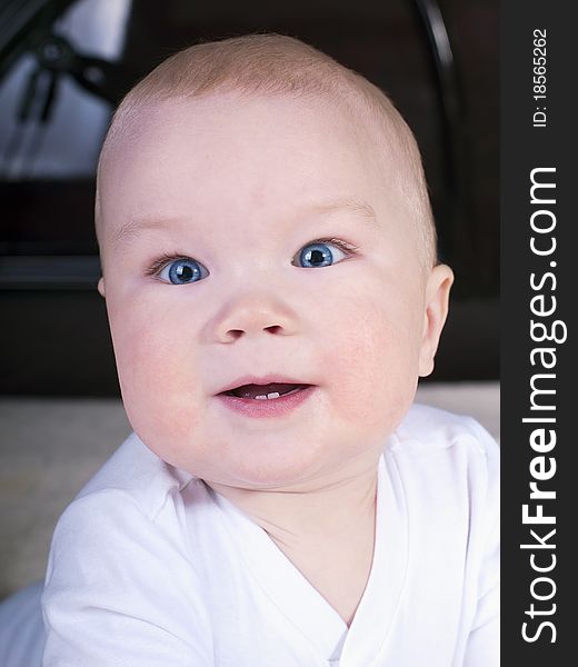 Baby with blue eyes, crawling on the big bed.