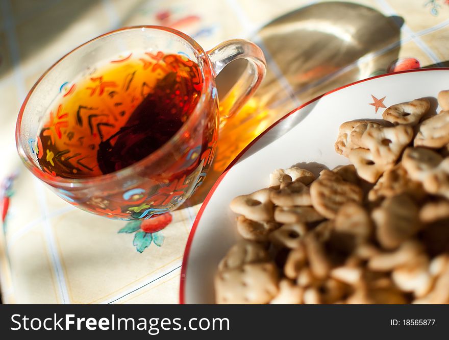 Closeup image of ceramic plate with crackers on it and a glass cup of tea. Closeup image of ceramic plate with crackers on it and a glass cup of tea