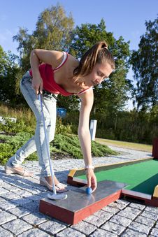 Attractive Young Woman Putting Golf Ball On Green Stock Photos