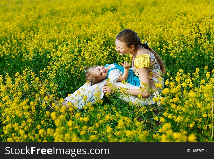 Mother with baby on yellow field