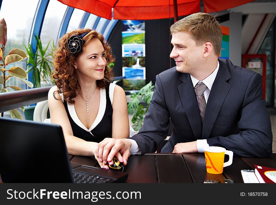 Young man and woman looking affectionately into each others eyes while sitting at a table in a cafe for lunch. Young man and woman looking affectionately into each others eyes while sitting at a table in a cafe for lunch