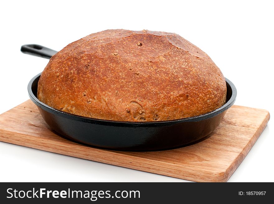 Home-made bread in frying pan isolated on white background with shadow