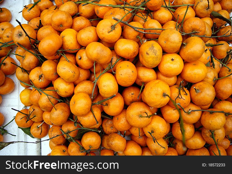 A heap of orange, in the market, waiting for people to buy. Orange is people enjoy eating fruit one.