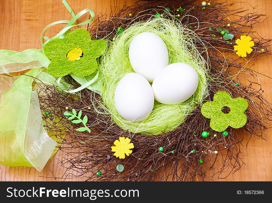 Spring nest with three white eggs in it