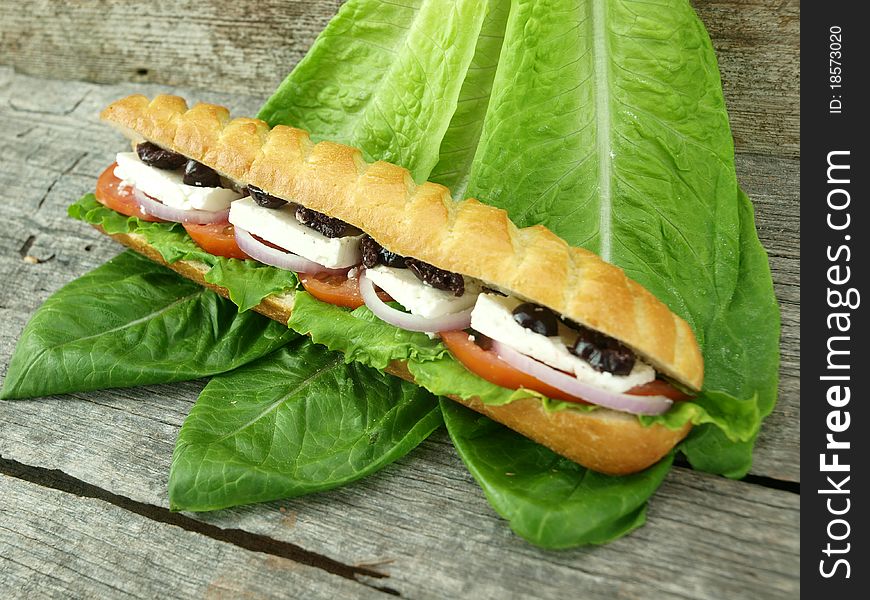 Mediterranean baguette with olives, feta cheese, onion, tomato and lettuce