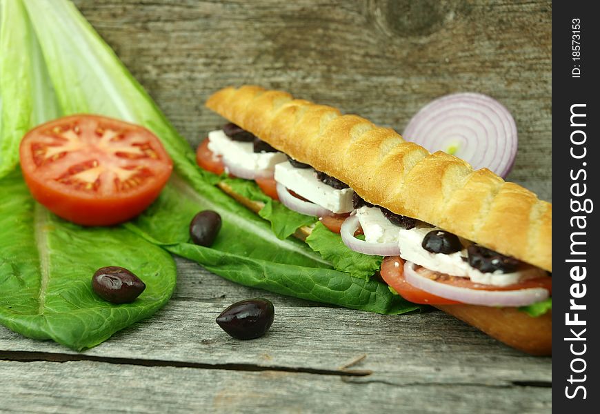 Mediterranean baguette with olives, feta cheese, onion, tomato and lettuce