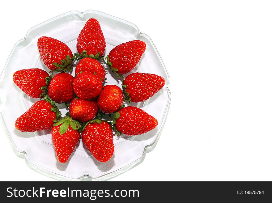 Strawberries on glass plate and white background