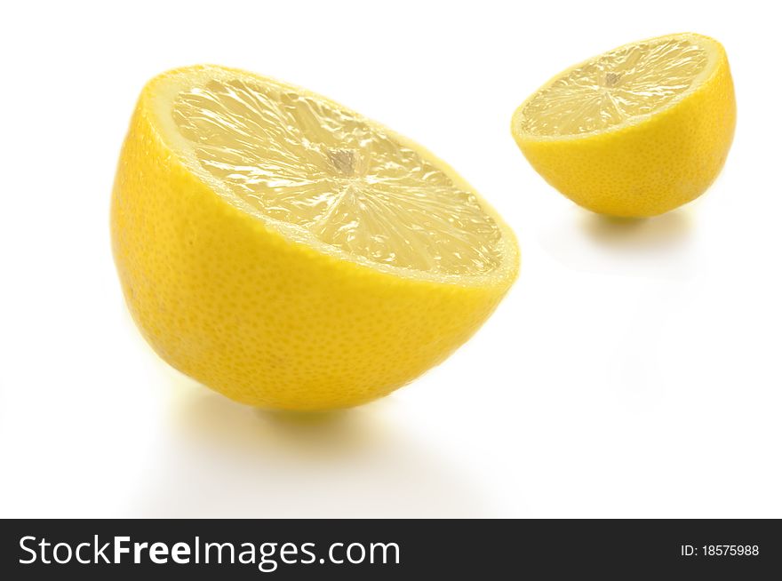 Two lemon halves arranged over white background