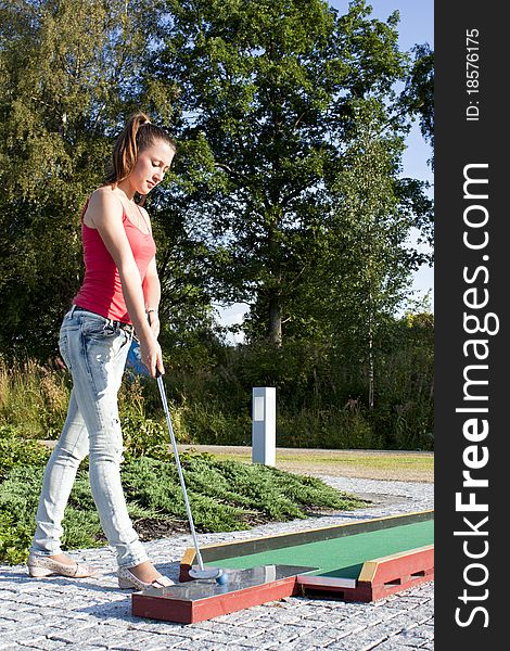 Young woman playing golf in a country club