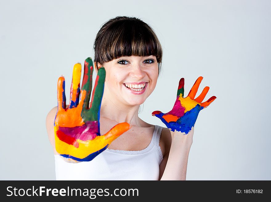 A girl with colored hands on a gray background