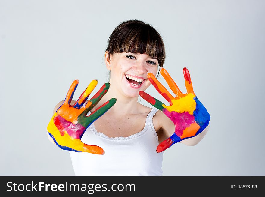 A girl with colored hands on a gray background